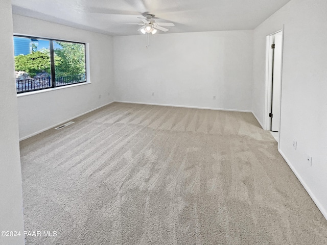 spare room with light colored carpet and ceiling fan