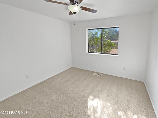 carpeted spare room with ceiling fan