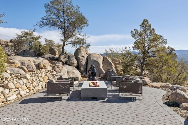 view of patio with an outdoor living space with a fire pit