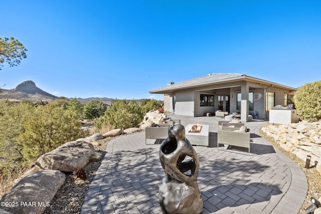 view of patio / terrace with a mountain view and an outdoor fire pit