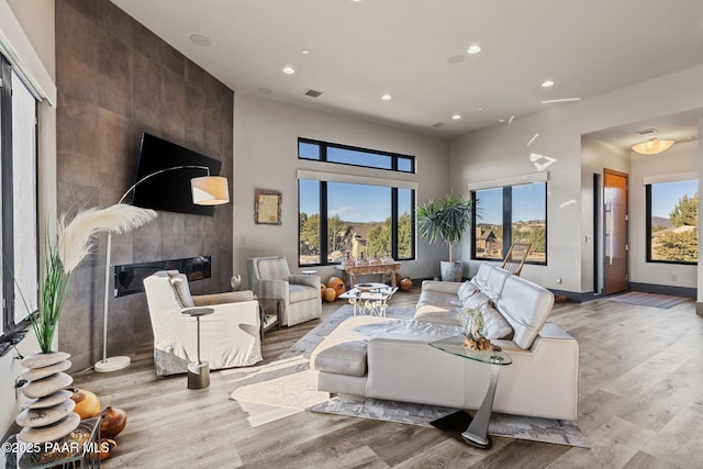 living room with light wood-type flooring and a large fireplace