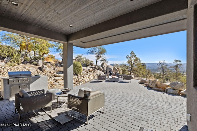 view of patio / terrace with outdoor lounge area, a mountain view, and area for grilling