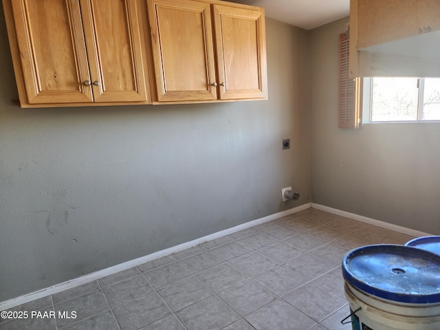 washroom with cabinet space, light tile patterned floors, baseboards, and electric dryer hookup