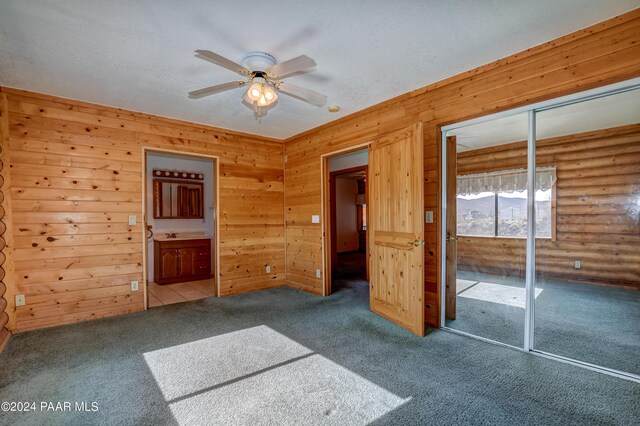 2570 S Colina Ln, Dewey-Humboldt, AZ 86329 - empty room featuring carpet floors, a ceiling fan, wood walls, and rustic walls