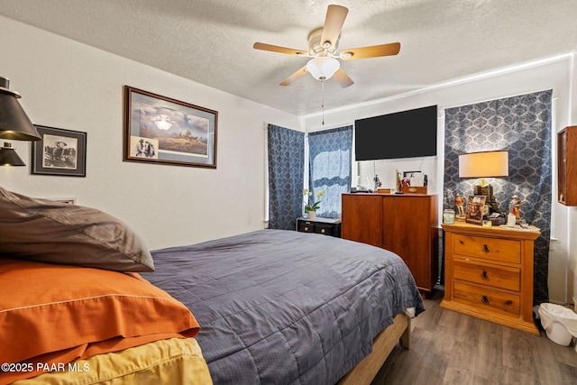 bedroom with ceiling fan, a textured ceiling, and wood finished floors