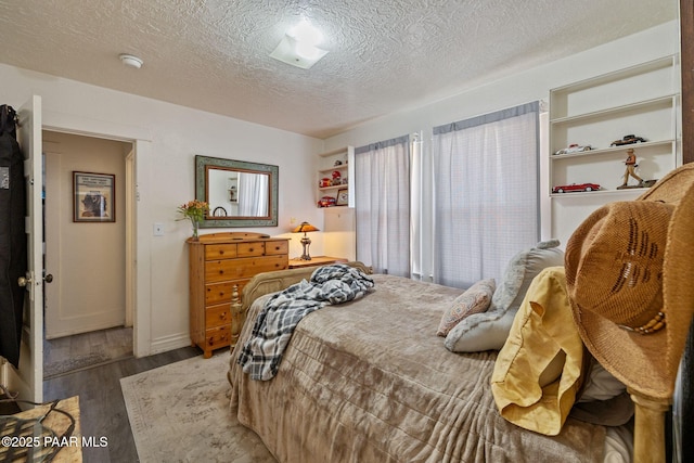 bedroom featuring a textured ceiling and wood finished floors