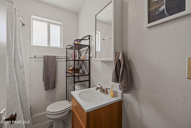 bathroom featuring a shower with shower curtain, toilet, vanity, and a textured wall