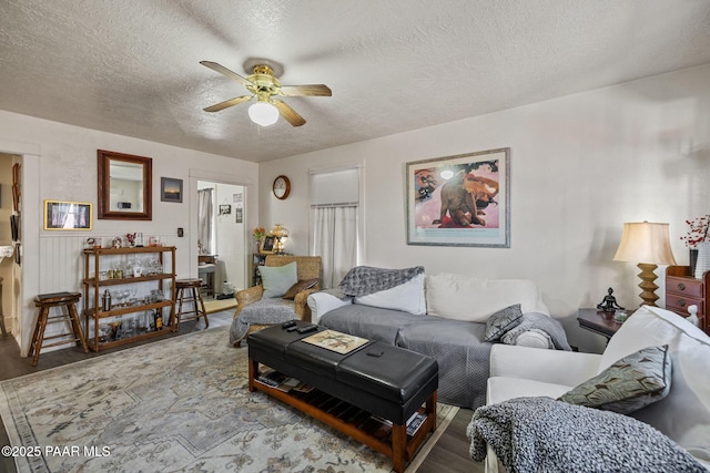 living area with a textured ceiling, wood finished floors, and ceiling fan