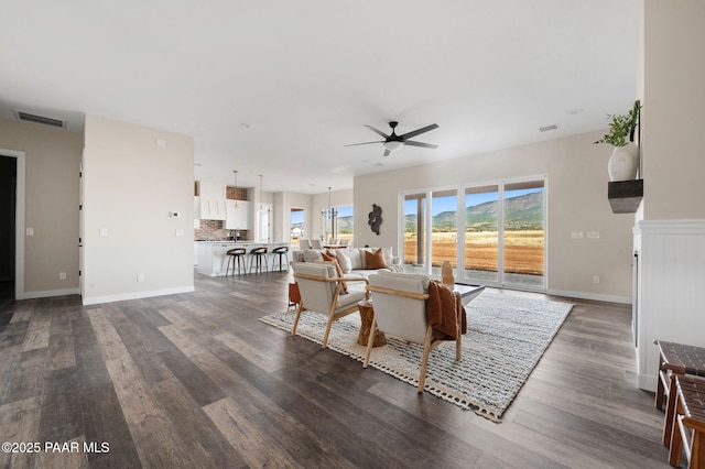 living area featuring baseboards, dark wood-style floors, ceiling fan, and visible vents