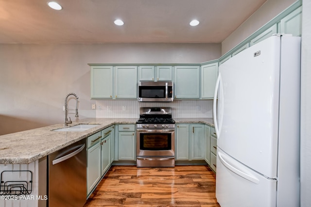 1017 N Fairway Dr, Dewey-Humboldt, AZ 86327 - kitchen with appliances with stainless steel finishes, a sink, a peninsula, light stone countertops, and light wood-style floors