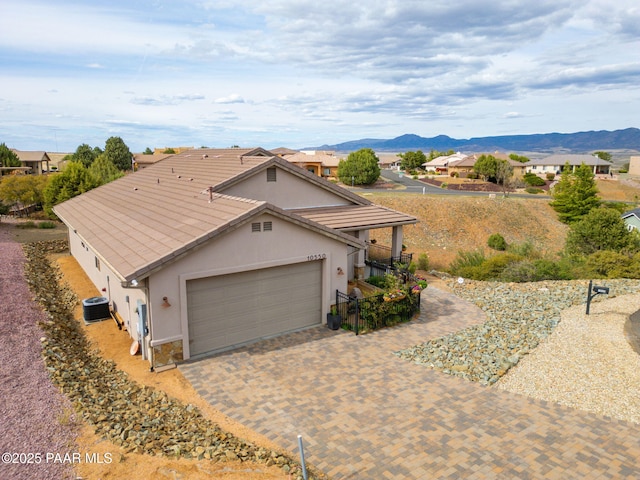 10550 E Cumberland Ct, Dewey-Humboldt, AZ 86327 - view of front of property featuring stucco siding, a garage, a mountain view, and central air condition unit