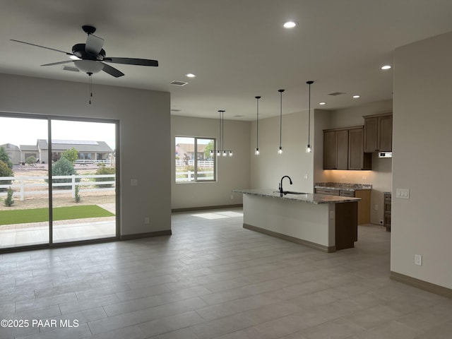 218 Brenna Dr, Chino Valley, AZ 86323 - kitchen with a sink, ceiling fan, recessed lighting, dark stone counters, and a center island with sink