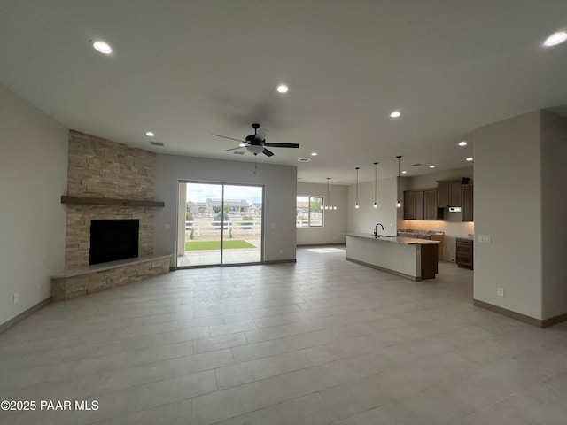 218 Brenna Dr, Chino Valley, AZ 86323 - unfurnished living room with a sink, ceiling fan, recessed lighting, baseboards, and a stone fireplace