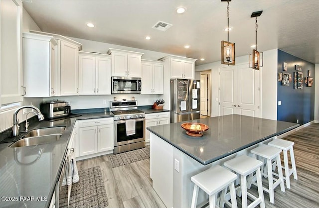 1680 Bainbridge Ln, Chino Valley, AZ 86323 - kitchen with appliances with stainless steel finishes, light wood finished floors, dark countertops, white cabinets, and recessed lighting