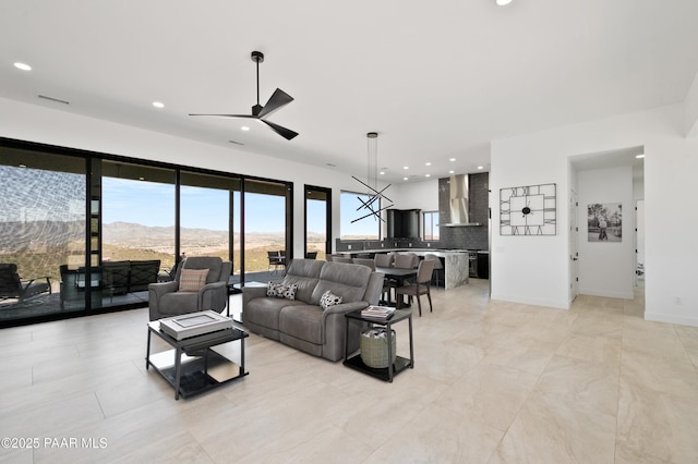 living room featuring ceiling fan and a mountain view