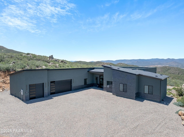 back of property with a garage and a mountain view