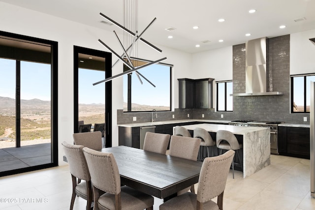 dining area featuring light tile patterned floors, sink, a wealth of natural light, and a mountain view