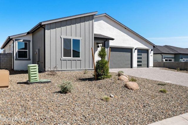 7492 E Louie Ln, Prescott Valley, AZ 86315 - view of front facade featuring decorative driveway, board and batten siding, fence, and an attached garage