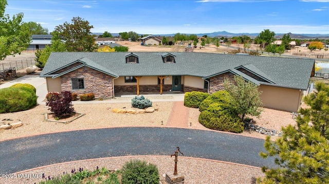 1640 W Grasshopper Ln, Chino Valley, AZ 86323 - view of front of property featuring stone siding, fence, a shingled roof, and a mountain view