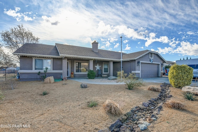 single story home with a chimney, an attached garage, fence, and stucco siding