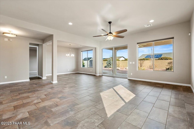 empty room with a healthy amount of sunlight and ceiling fan with notable chandelier