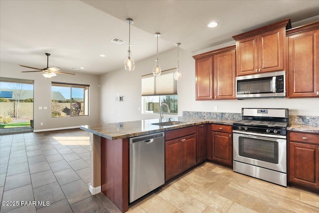 kitchen with sink, hanging light fixtures, kitchen peninsula, and appliances with stainless steel finishes