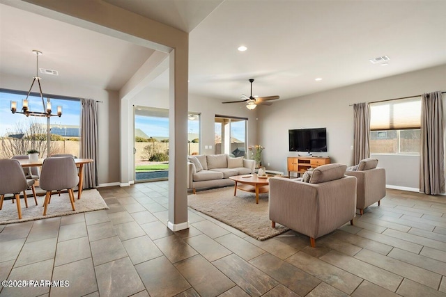 living room with ceiling fan with notable chandelier