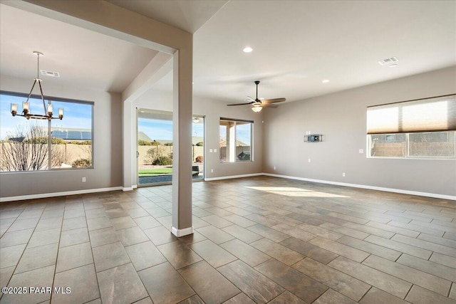 unfurnished living room with ceiling fan with notable chandelier