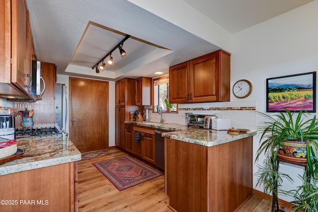 930 Ohio St, Prescott, AZ 86303 - kitchen with a sink, brown cabinetry, light wood-style floors, and appliances with stainless steel finishes