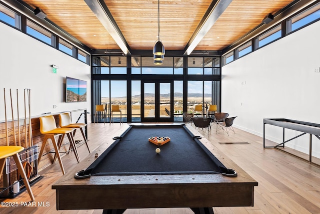 rec room with wood ceiling, floor to ceiling windows, light hardwood / wood-style flooring, and beamed ceiling