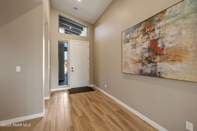 entryway with vaulted ceiling and light hardwood / wood-style floors