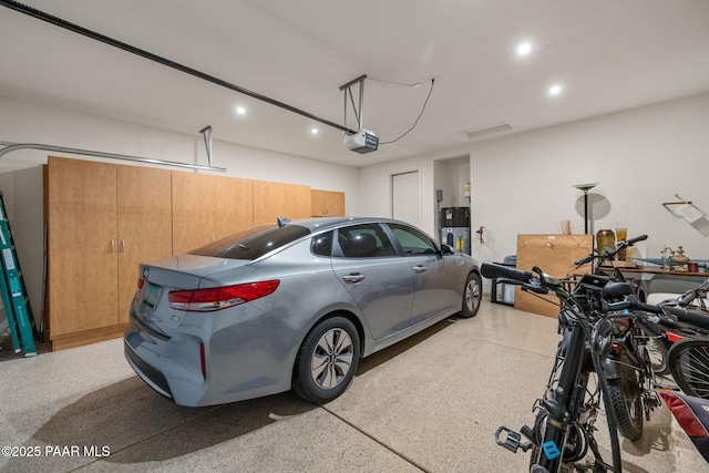 garage featuring a garage door opener and hybrid water heater