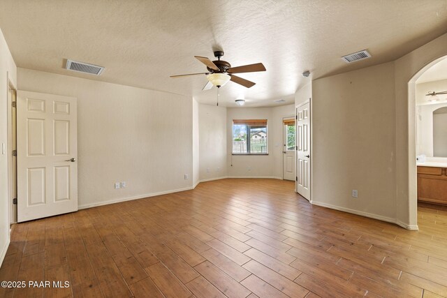 25870 N Merlot Ln, Paulden, AZ 86334 - unfurnished room featuring ceiling fan, arched walkways, wood finished floors, baseboards, and a textured ceiling