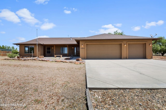 25870 N Merlot Ln, Paulden, AZ 86334 - view of front facade with an attached garage, driveway, and stucco siding