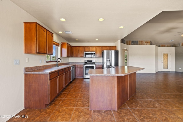 25870 N Merlot Ln, Paulden, AZ 86334 - kitchen with stainless steel appliances, a sink, brown cabinetry, recessed lighting, and open floor plan