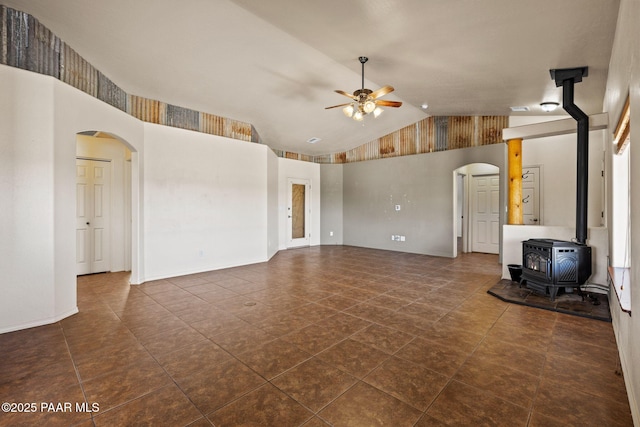 25870 N Merlot Ln, Paulden, AZ 86334 - unfurnished living room featuring ceiling fan, a wood stove, arched walkways, and high vaulted ceiling