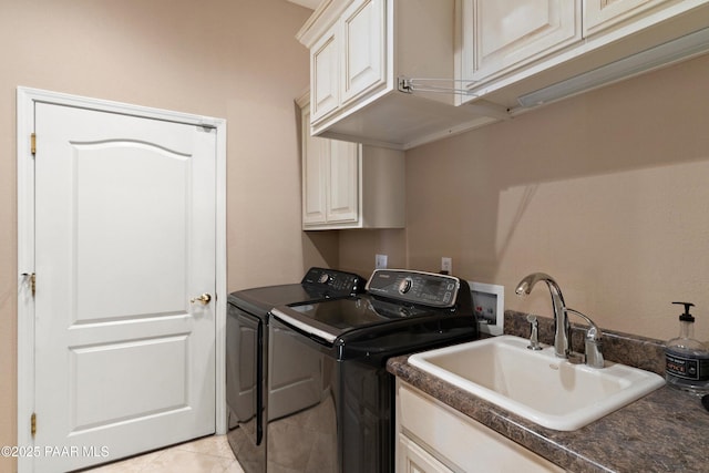 washroom featuring washing machine and clothes dryer, cabinet space, a sink, and light tile patterned floors