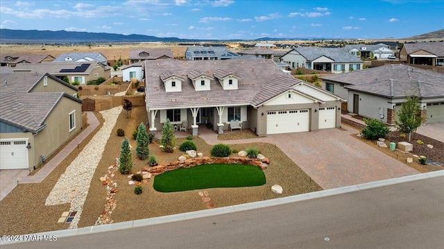 view of front of property featuring a mountain view, a porch, and a garage