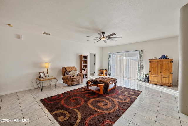 tiled living room featuring a textured ceiling and ceiling fan