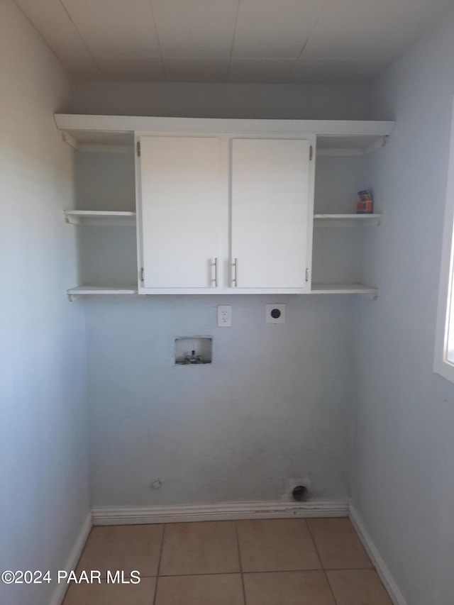 washroom featuring cabinets, hookup for a washing machine, light tile patterned floors, and hookup for an electric dryer