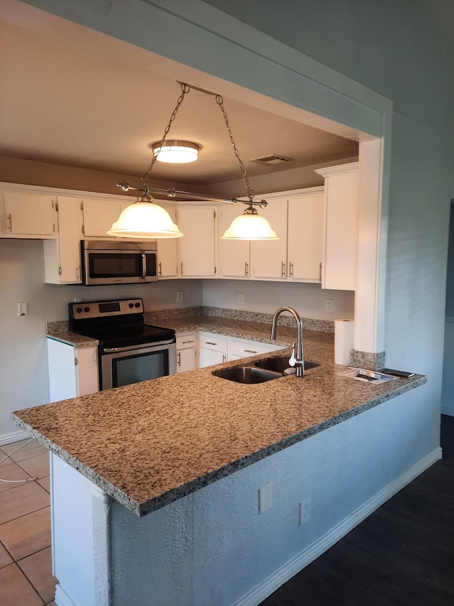 kitchen featuring white cabinets, pendant lighting, and appliances with stainless steel finishes