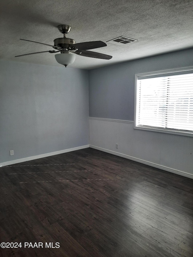 unfurnished room with dark hardwood / wood-style floors, ceiling fan, and a textured ceiling