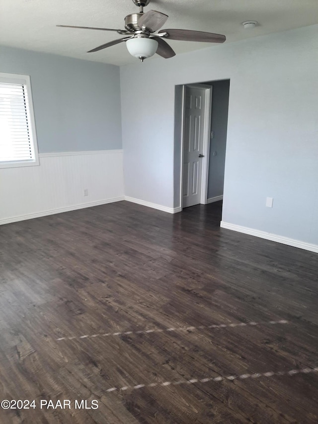 spare room with ceiling fan and dark hardwood / wood-style flooring