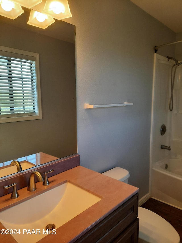 full bathroom featuring vanity, hardwood / wood-style flooring, toilet, and shower / washtub combination