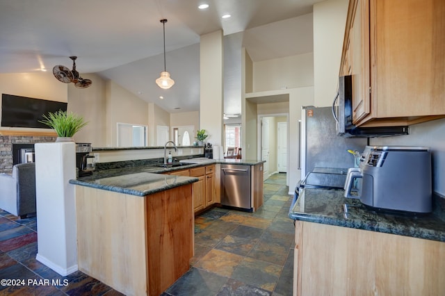 kitchen with light brown cabinets, sink, dark stone countertops, kitchen peninsula, and stainless steel appliances