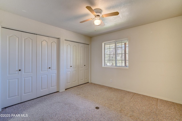 2785 W Bard Ranch Rd, Prescott, AZ 86305 - unfurnished bedroom featuring two closets, carpet flooring, a ceiling fan, and a textured ceiling