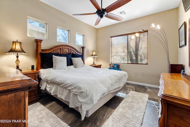 bedroom with multiple windows, ceiling fan, and dark wood-type flooring