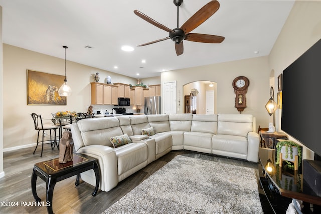 living room featuring ceiling fan and dark wood-type flooring