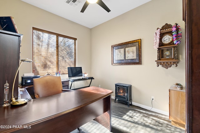 office featuring ceiling fan and a wood stove