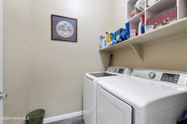 clothes washing area with washer and dryer and dark hardwood / wood-style floors